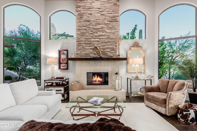 living room with a tiled fireplace and hardwood / wood-style flooring