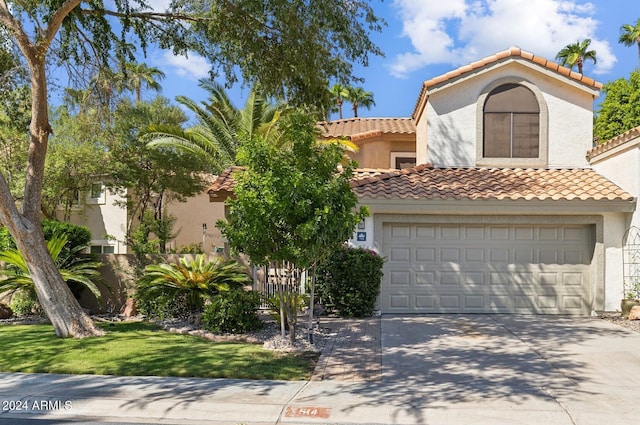 mediterranean / spanish home with a garage and a front lawn