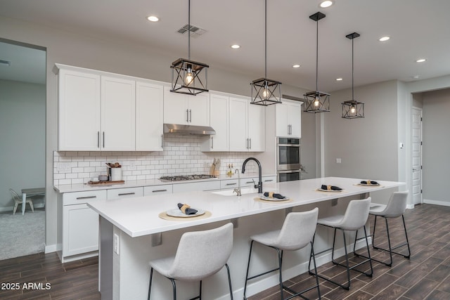 12702 W Sierra Vista Dr, Glendale, AZ 85307 - kitchen with visible vents, appliances with stainless steel finishes, a sink, under cabinet range hood, and backsplash