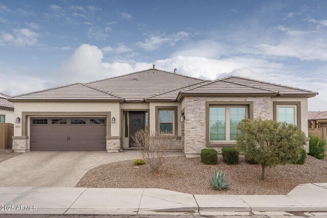 12702 W Sierra Vista Dr, Glendale, AZ 85307 - prairie-style house featuring a garage, concrete driveway, stone siding, a tile roof, and stucco siding