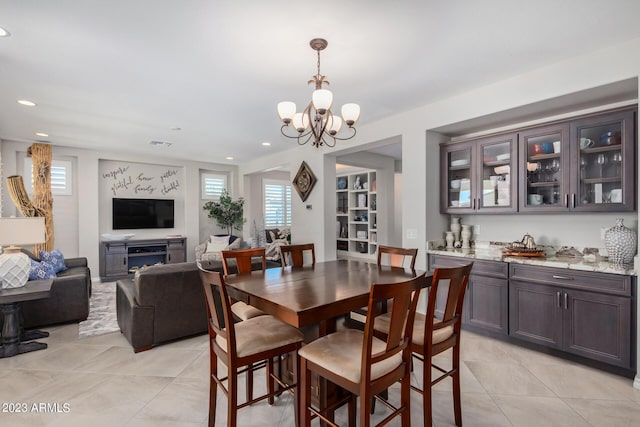 tiled dining area featuring a chandelier