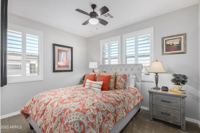 bedroom featuring multiple windows, ceiling fan, and dark colored carpet