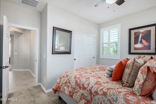 bedroom with light colored carpet, a closet, and ceiling fan