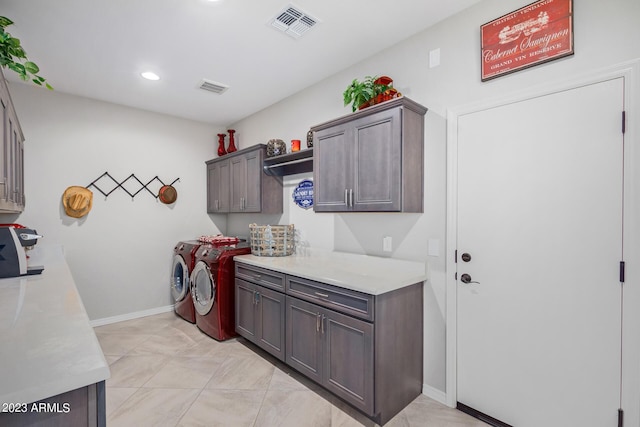 washroom with cabinets and washing machine and clothes dryer