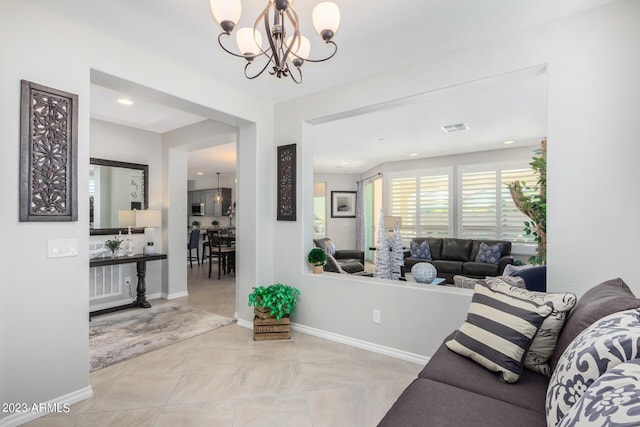 tiled living room featuring a notable chandelier