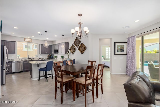 tiled dining space featuring a notable chandelier and sink