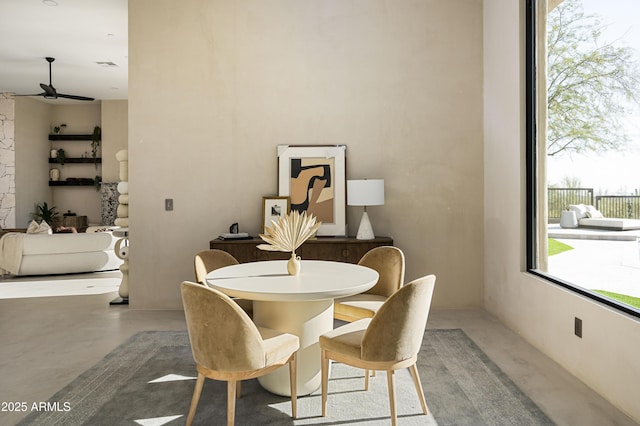 dining space with concrete flooring and ceiling fan