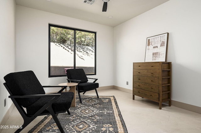 living area featuring visible vents, a ceiling fan, and baseboards