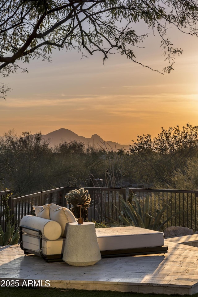 patio terrace at dusk featuring a mountain view