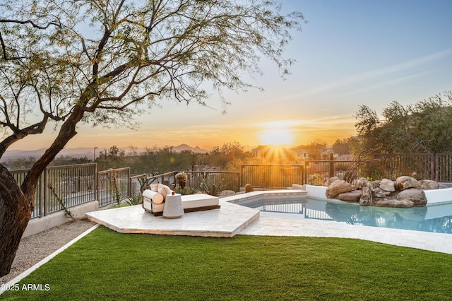 yard at dusk featuring fence, a fenced in pool, and a patio