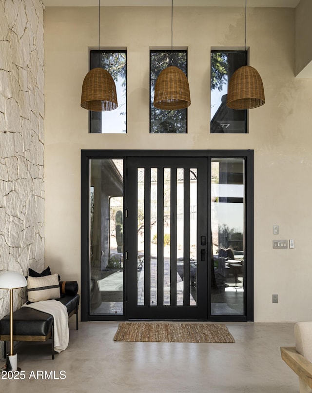 foyer entrance featuring a high ceiling and concrete floors