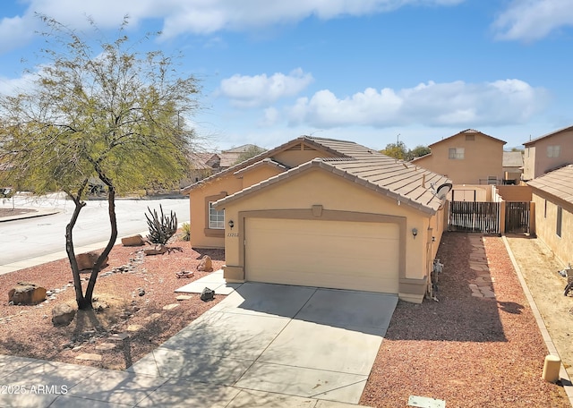 view of front of property with stucco siding, an attached garage, fence, driveway, and a tiled roof