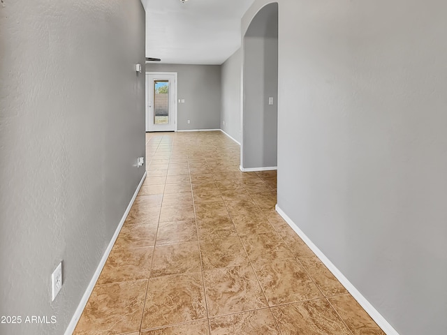 hallway with baseboards and tile patterned floors