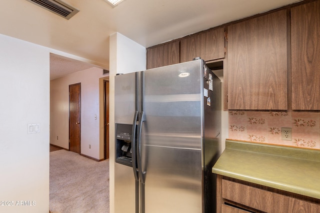 1654 E 2nd St, Mesa, AZ 85203 - kitchen featuring stainless steel fridge, light carpet, light countertops, brown cabinetry, and baseboards