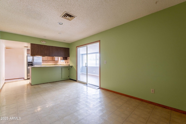 1654 E 2nd St, Mesa, AZ 85203 - kitchen with a peninsula, light countertops, a textured ceiling, stainless steel fridge with ice dispenser, and green cabinetry
