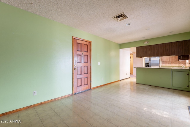 1654 E 2nd St, Mesa, AZ 85203 - kitchen with green cabinets, stainless steel appliances, a textured ceiling, light countertops, and light flooring
