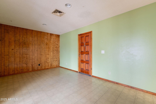 1654 E 2nd St, Mesa, AZ 85203 - spare room with tile patterned floors, baseboards, and wooden walls