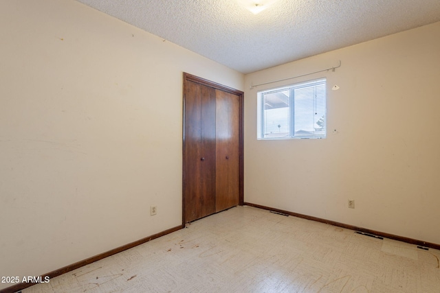 1654 E 2nd St, Mesa, AZ 85203 - unfurnished bedroom with a textured ceiling, a closet, and baseboards