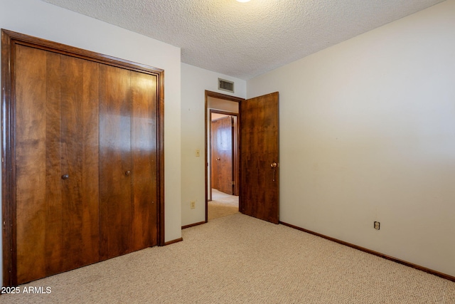 1654 E 2nd St, Mesa, AZ 85203 - unfurnished bedroom featuring light colored carpet, a closet, a textured ceiling, and baseboards