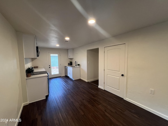 kitchen with stove, dark hardwood / wood-style floors, sink, and white cabinetry