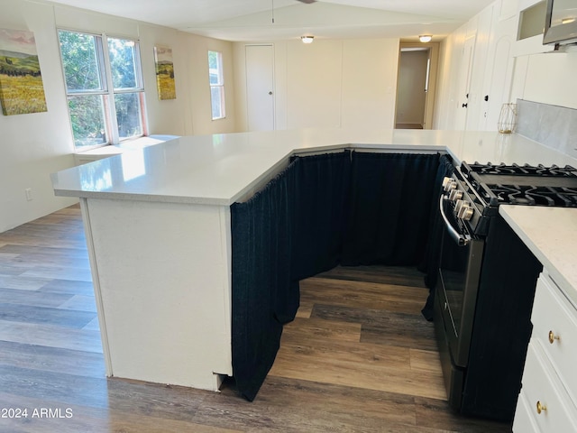 kitchen with dark wood-type flooring, white cabinets, and black range with gas cooktop