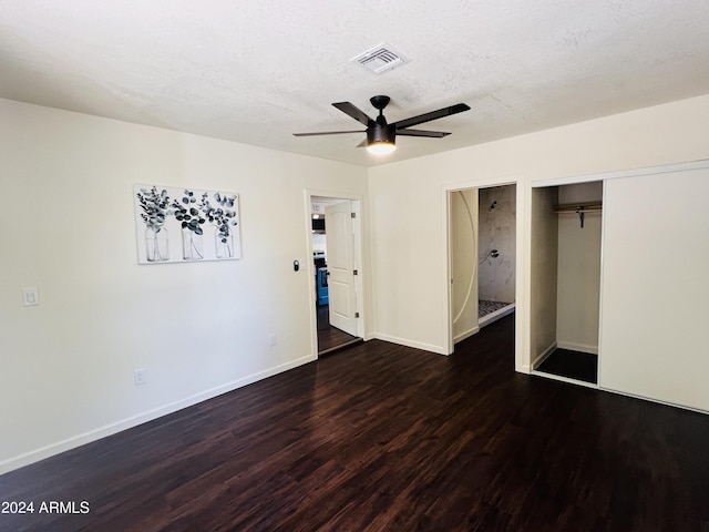 unfurnished bedroom with ceiling fan, dark wood-type flooring, and a textured ceiling