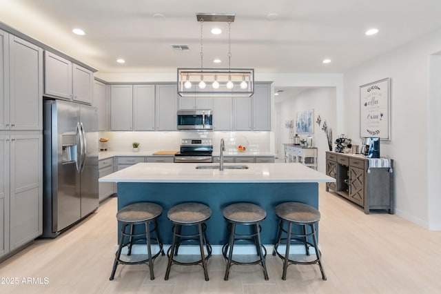 24638 N 144th Ave, Surprise, AZ 85387 - kitchen featuring appliances with stainless steel finishes, gray cabinets, a breakfast bar area, and recessed lighting