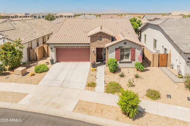 24638 N 144th Ave, Surprise, AZ 85387 - view of front of house featuring a tiled roof, stucco siding, a gate, an attached garage, and driveway