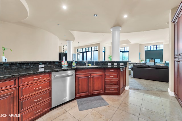 kitchen with light carpet, dark stone counters, sink, decorative columns, and stainless steel dishwasher