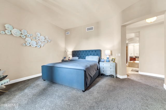 bedroom featuring ensuite bathroom and carpet flooring