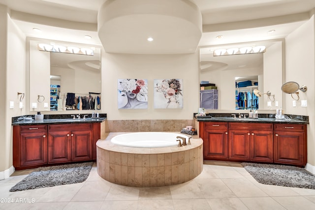 bathroom with vanity, a relaxing tiled tub, and tile patterned floors