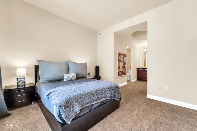 bedroom featuring connected bathroom and carpet