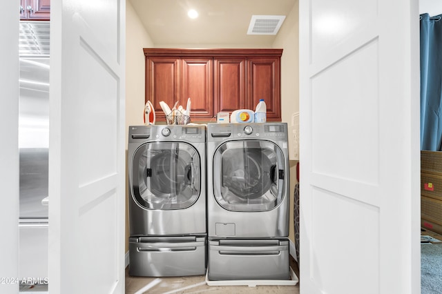 laundry room featuring independent washer and dryer and cabinets