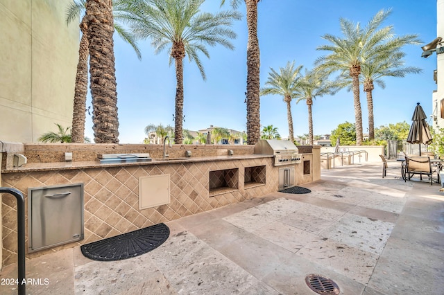 view of patio / terrace with an outdoor kitchen, sink, and a grill