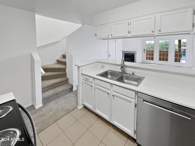 kitchen with light tile patterned flooring, stove, sink, white cabinets, and dishwasher