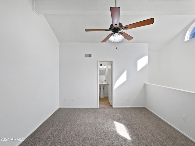 carpeted spare room featuring sink, vaulted ceiling, and ceiling fan