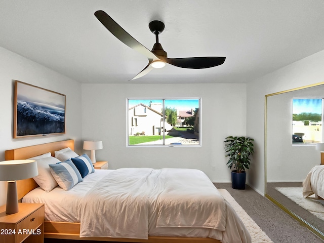 carpeted bedroom featuring multiple windows and ceiling fan