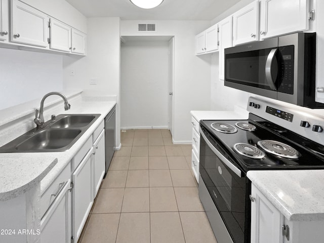 kitchen with stainless steel appliances, white cabinetry, sink, and light tile patterned floors