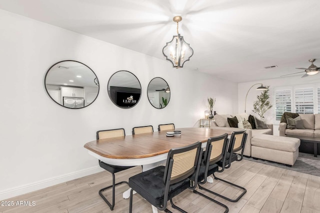8437 E Bonnie Rose Ave, Scottsdale, AZ 85250 - dining room featuring light wood-type flooring, a chandelier, a ceiling fan, and baseboards