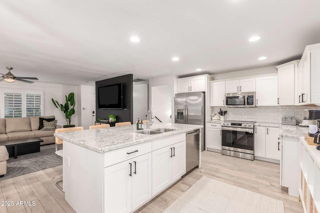 8437 E Bonnie Rose Ave, Scottsdale, AZ 85250 - kitchen featuring stainless steel appliances, a sink, open floor plan, white cabinets, and a kitchen island with sink