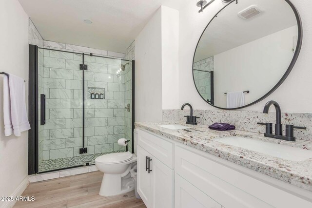8437 E Bonnie Rose Ave, Scottsdale, AZ 85250 - bathroom featuring a shower stall, toilet, wood finished floors, and double vanity