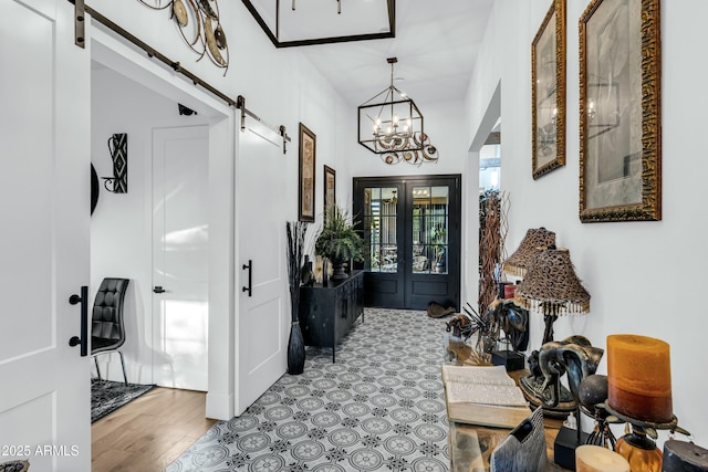 908 W Caldwell St, Phoenix, AZ 85041 - foyer with french doors, an inviting chandelier, wood finished floors, and a barn door