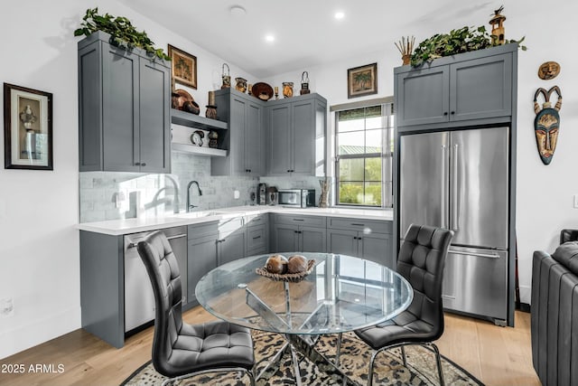 908 W Caldwell St, Phoenix, AZ 85041 - kitchen with light wood-type flooring, light countertops, open shelves, decorative backsplash, and stainless steel appliances