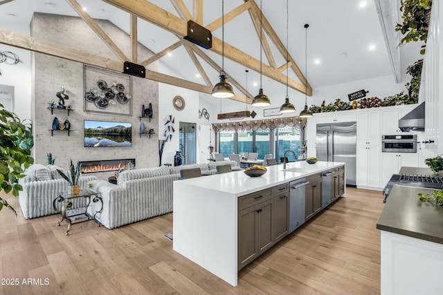 908 W Caldwell St, Phoenix, AZ 85041 - kitchen featuring light wood finished floors, a sink, wall chimney range hood, and stainless steel appliances