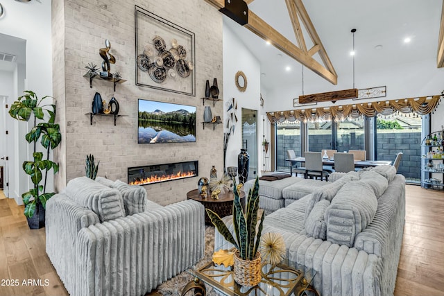 908 W Caldwell St, Phoenix, AZ 85041 - living area with a fireplace, visible vents, beamed ceiling, high vaulted ceiling, and wood finished floors