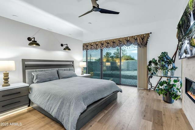 908 W Caldwell St, Phoenix, AZ 85041 - bedroom featuring access to outside, a ceiling fan, a glass covered fireplace, visible vents, and light wood finished floors