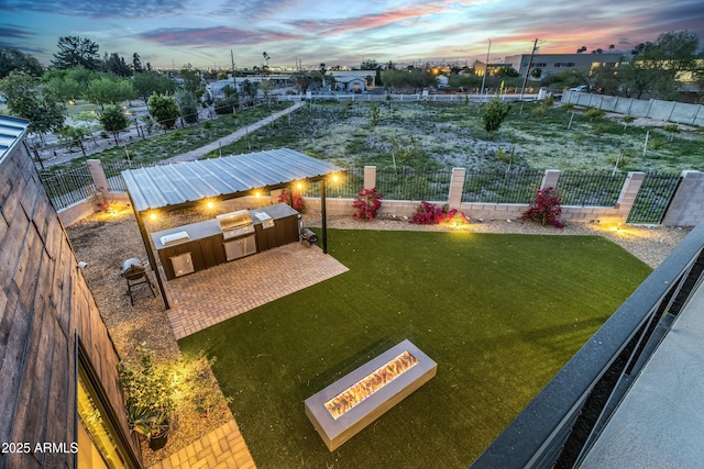 908 W Caldwell St, Phoenix, AZ 85041 - view of yard featuring a patio area, a fire pit, a fenced backyard, and an outdoor kitchen