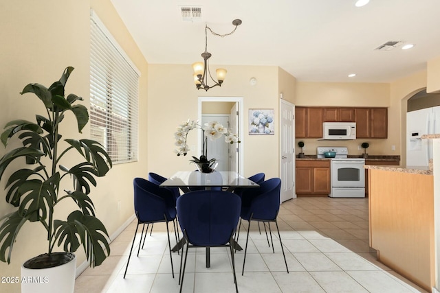 tiled dining room featuring a notable chandelier