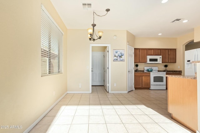 kitchen with pendant lighting, light tile patterned floors, white appliances, and an inviting chandelier