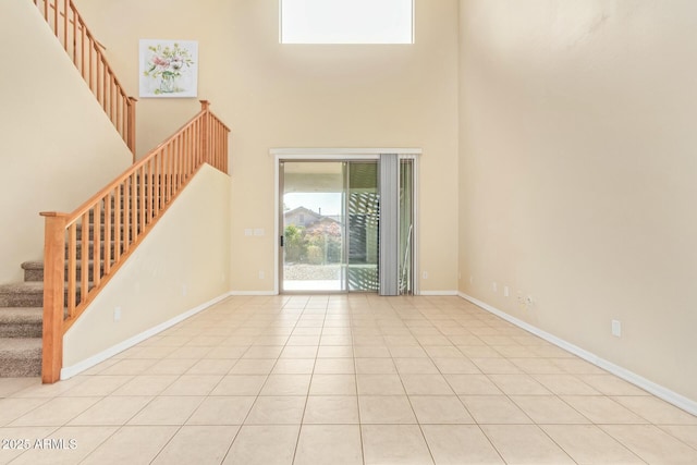 interior space featuring a towering ceiling and light tile patterned floors